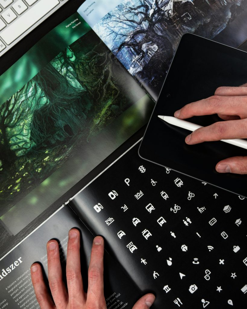 Picture of graphic artist working on tablet and book