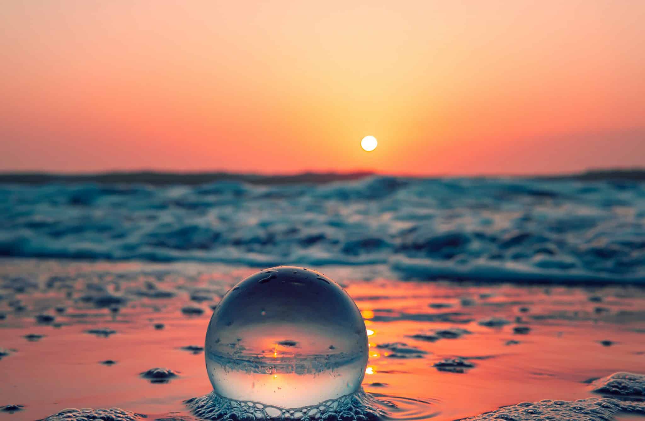 globe on a beach, at sunset